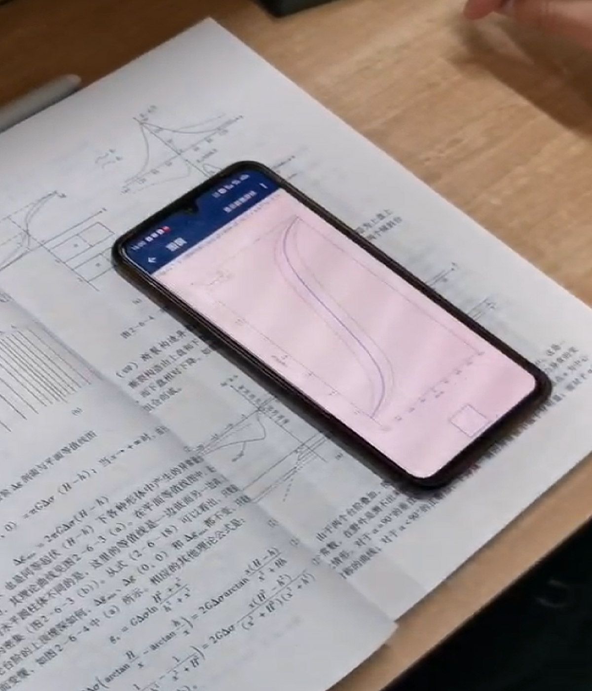 A textbook and mobile phone showing geophysical data processing using MATLAB Mobile.